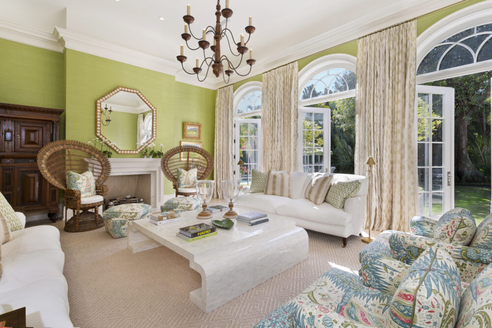 living room with bright green walls and 3 sets of arched french doors opening to backyard