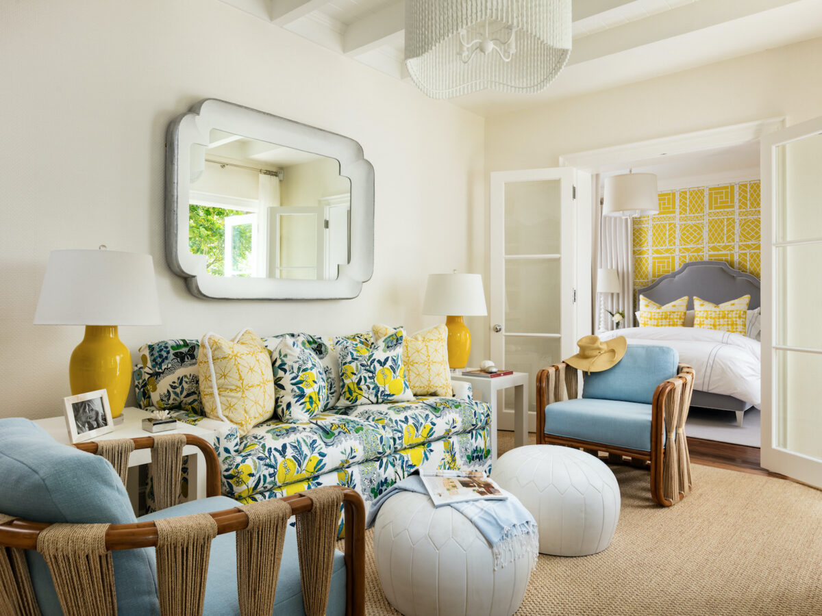 living room with blue and yellow accents and 2 white round ottomans