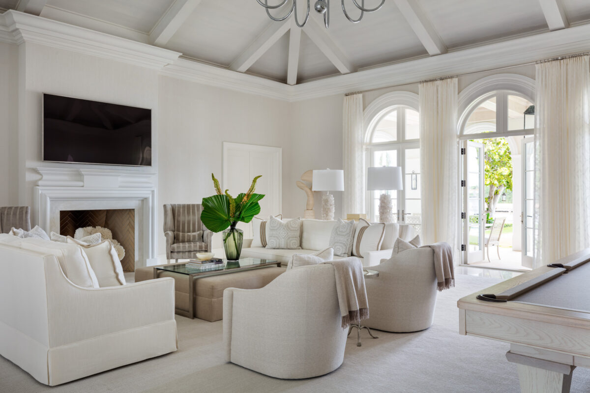 living room with arched french doors, vaulted ceiling and neutral sofas and chairs
