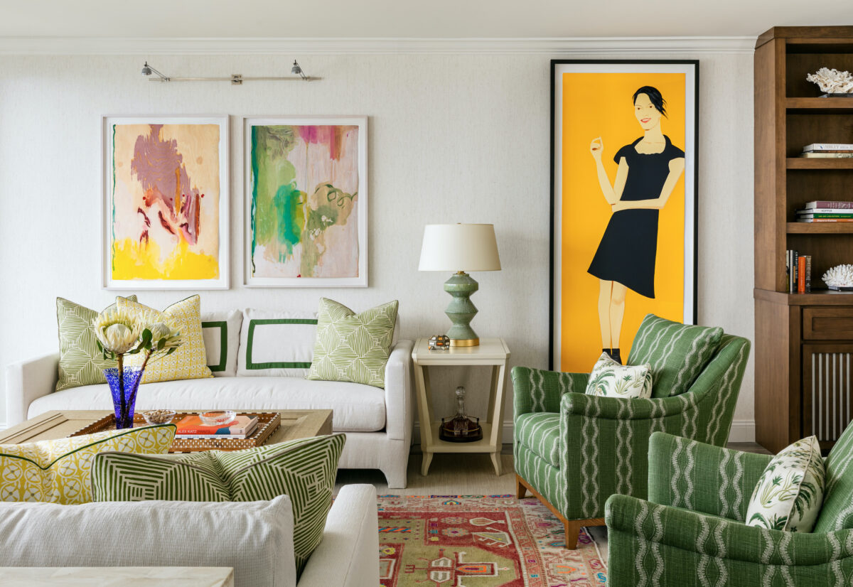 living room with white and green accents and brightly colored wall art