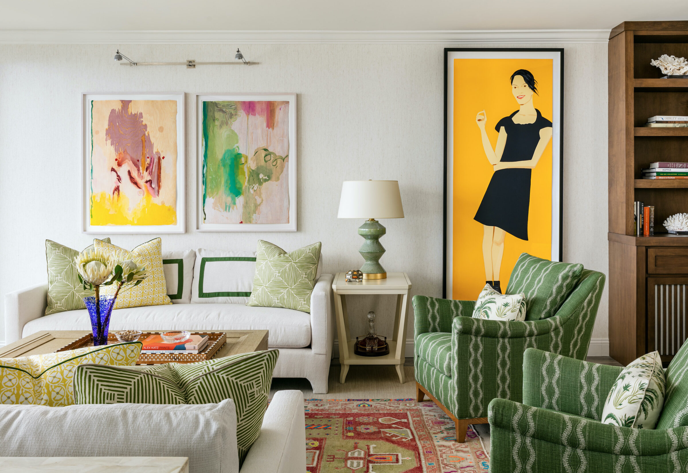 living room with white and green accents and brightly colored wall art