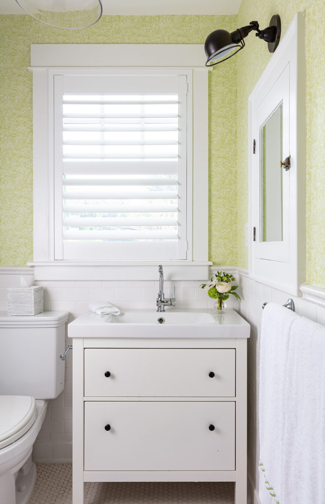 Image of Mango Cottage bathroom with green walls and white vanity beneath window