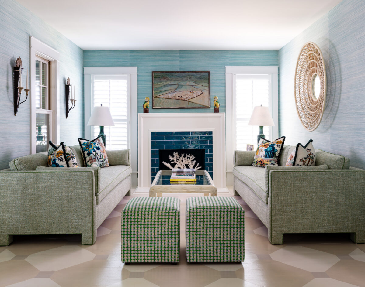 living room with green sofas, blue walls, and a blue tile fireplace