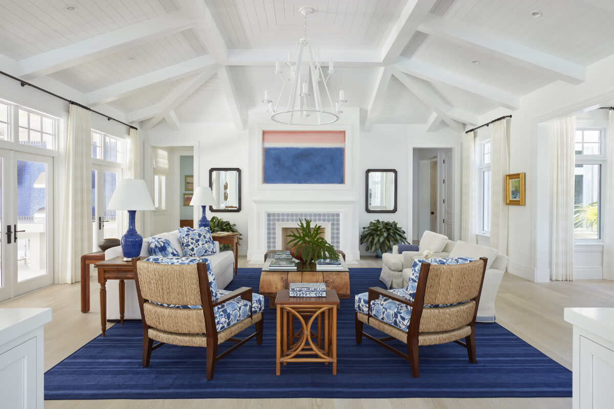 living room with white vaulted ceiling, fireplace, and blue cushions and accents
