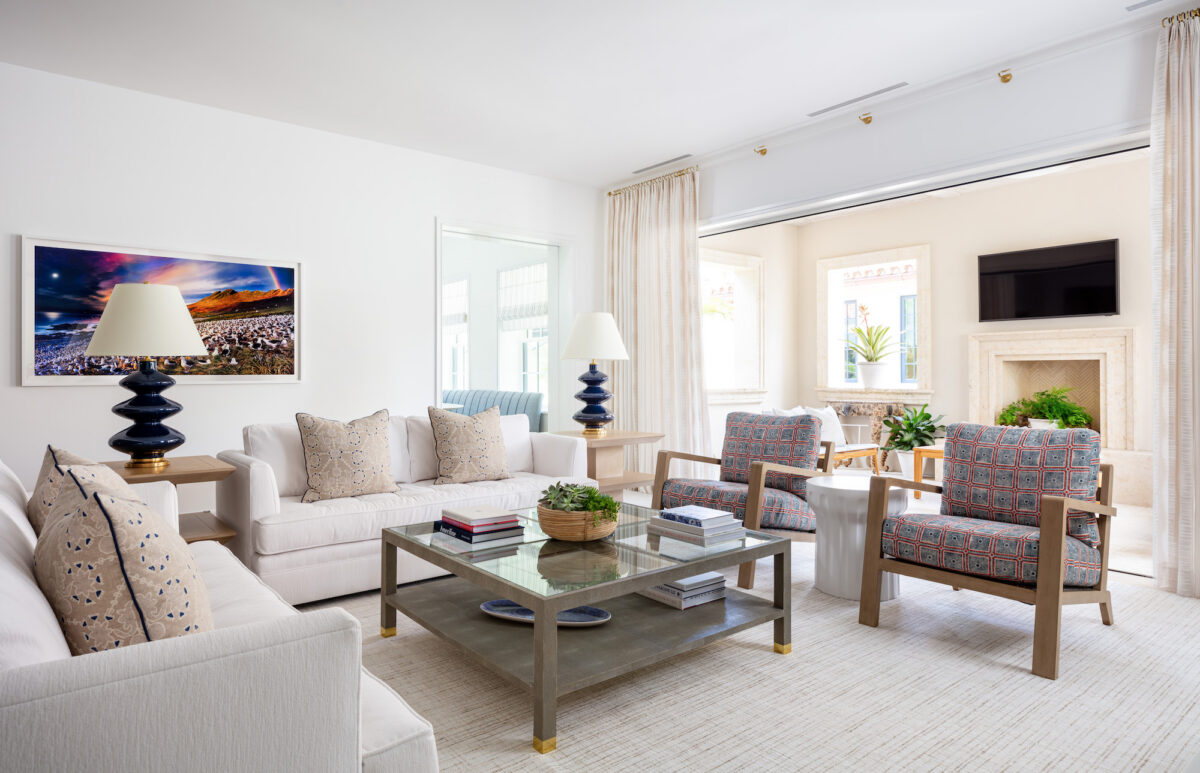 living area with neutral sofa, two wooden chairs, and wooden coffee table