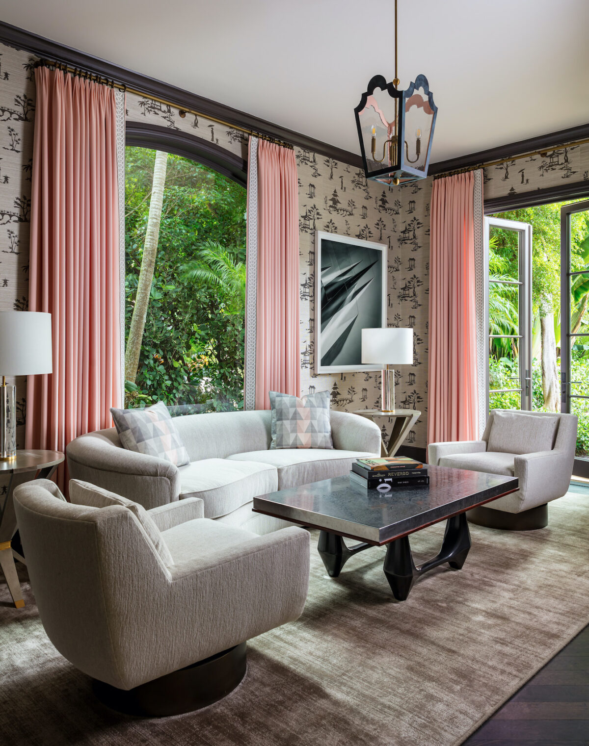 living area with black and white wallpaper, pink curtains, and neutral furniture