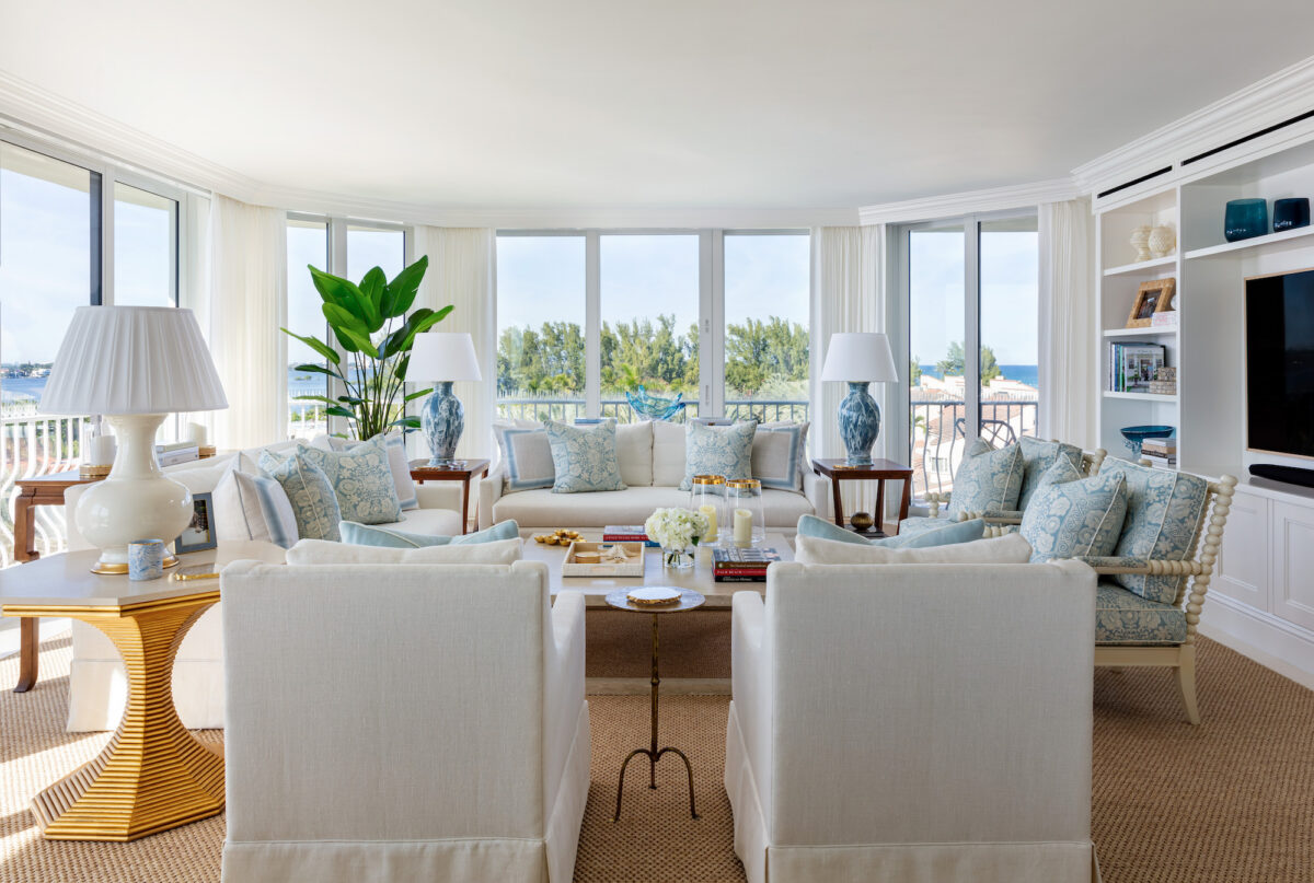 neutral living room with aqua accents and a wall of windows overlooking water