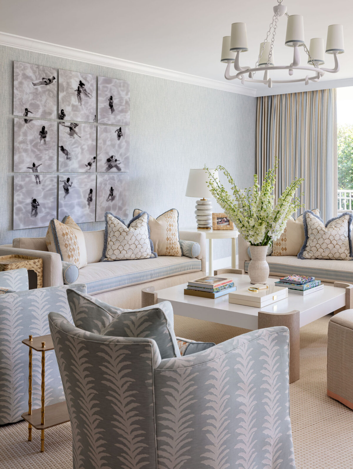 living room with blue and beige furniture and accents and tall flowers on coffee table