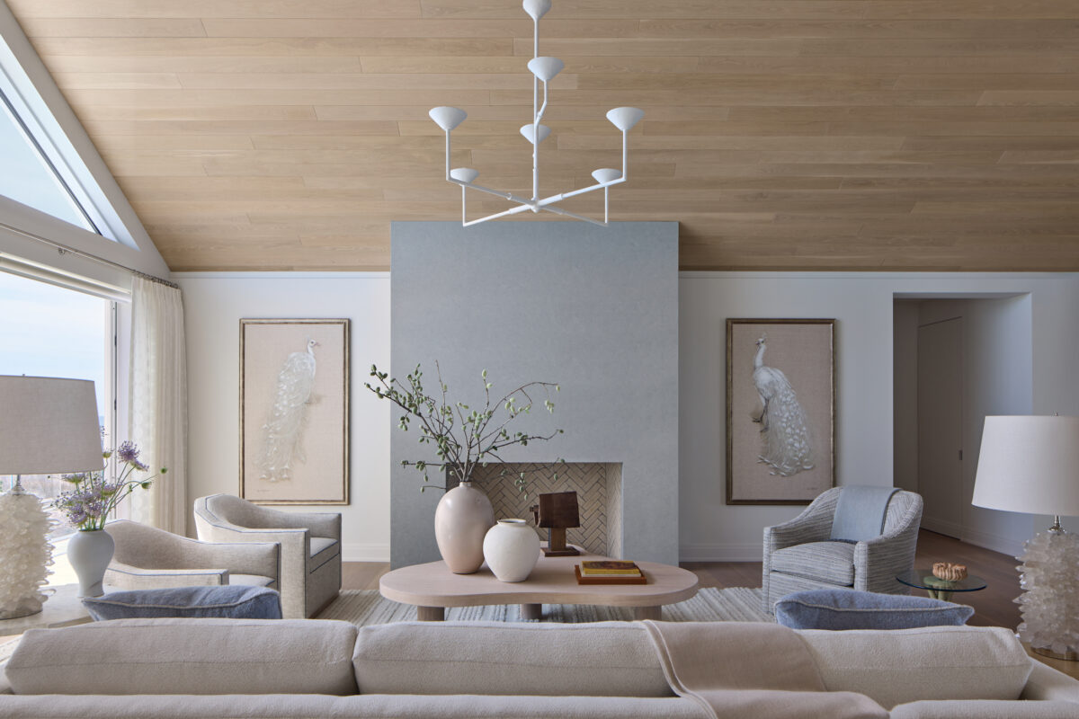 living room with blue fireplace, slanted wood ceiling, and round vases on table