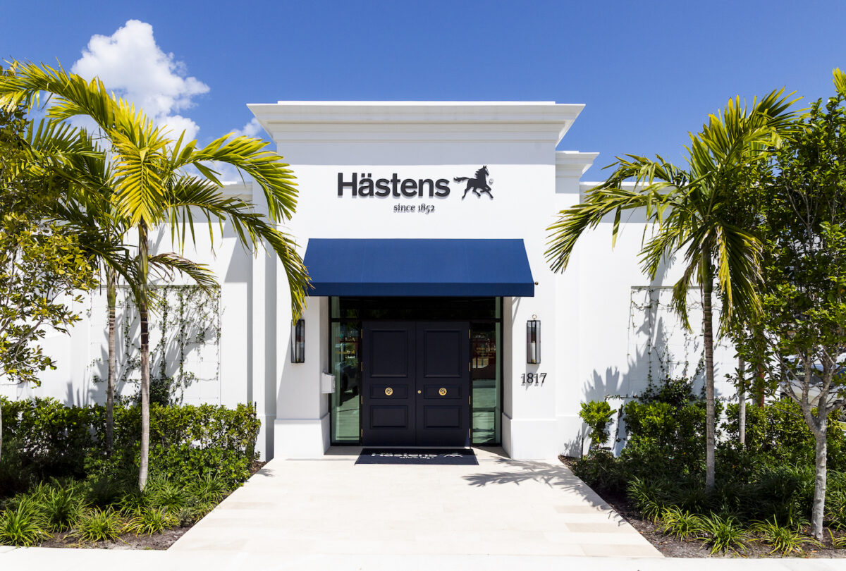 exterior of Hästens Palm Beach with logo over blue awning and palm trees