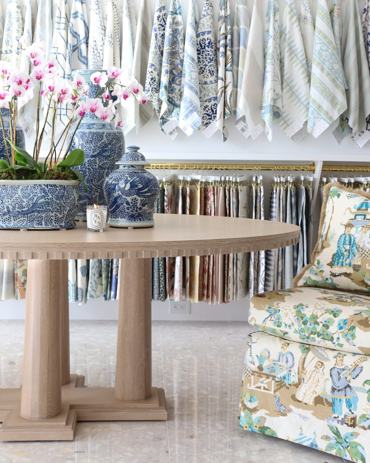 Hive trade showroom fabric swatch wall with a table and chair in front of it