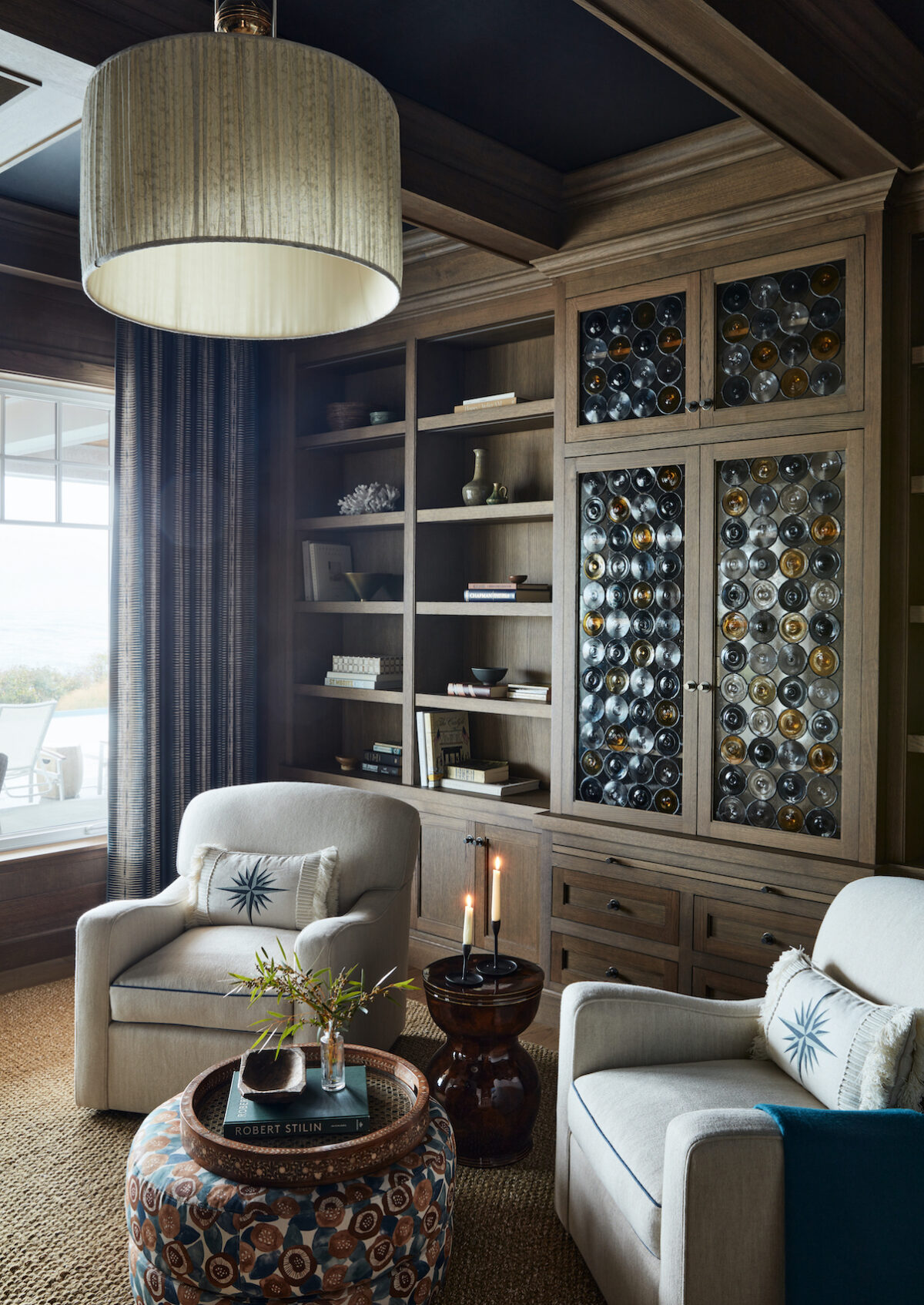 seating area with rondel glass cabinet, 2 chairs and lit candle on table