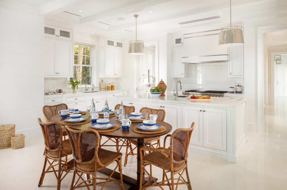 kitchen with white cabinets and a dining area with rattan chairs