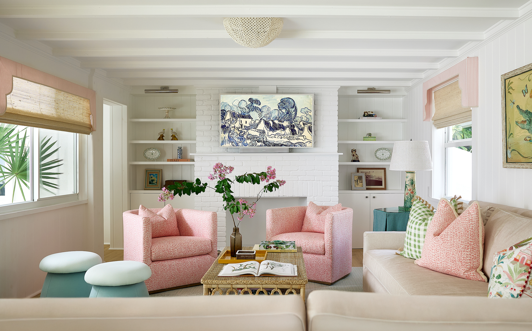 living room with white brick fireplace, pink chairs, a beige sofa, and built in shelving