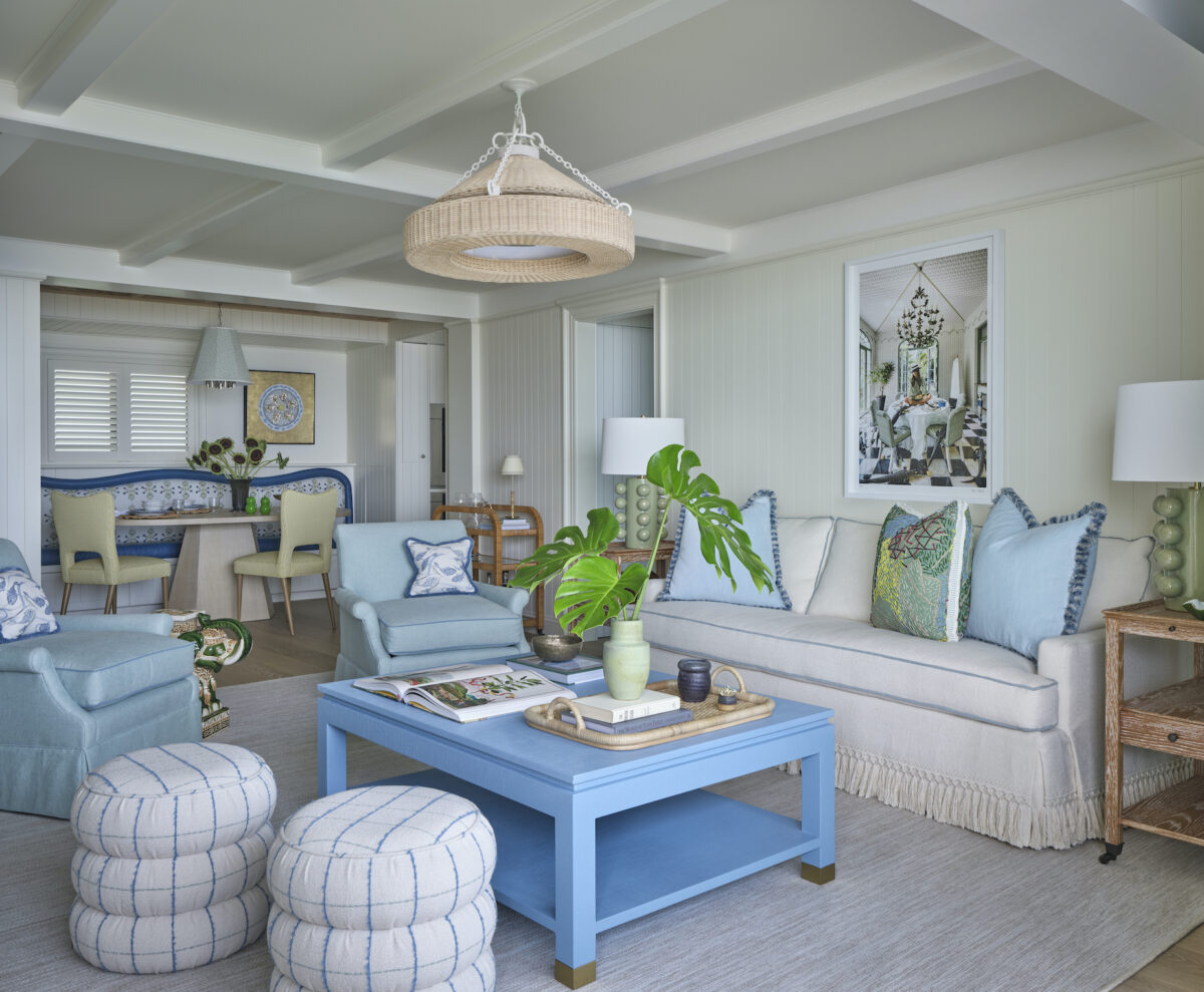 Living room with blue and green accents, white sofa with tassel fringe, 2 aqua chairs, and blue coffee table.
